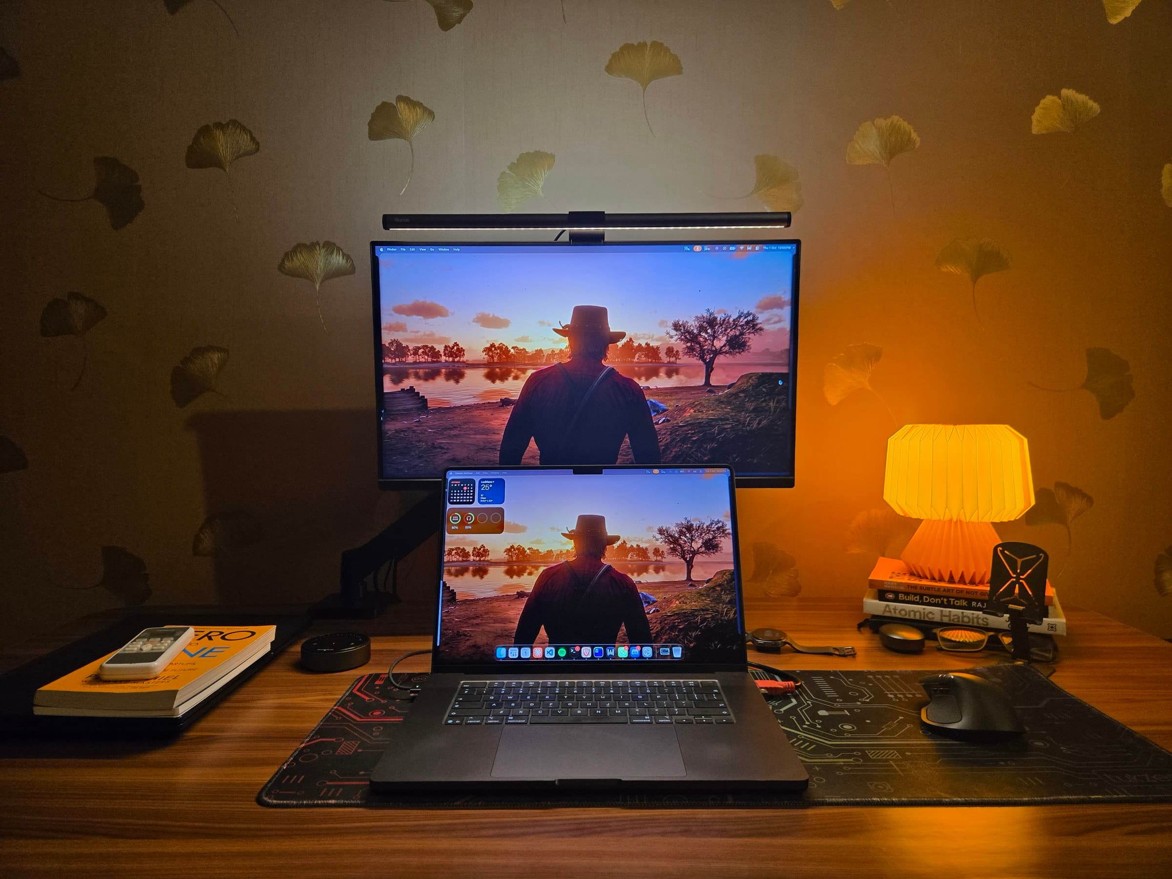 My desk at night: the MacBook Pro in front of the MSI monitor, the MX Master on a circuit-print desk mat, a paper lamp to the right